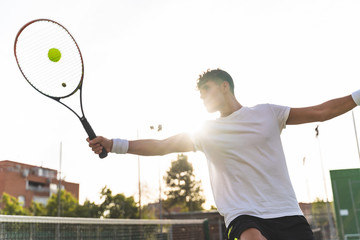 Wall Mural - Young Man Playing Tennis Outdoors.