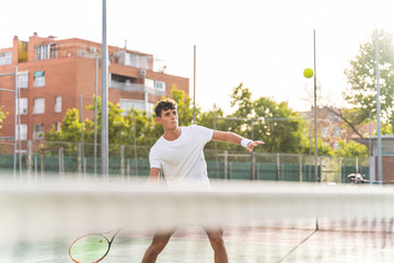 Wall Mural - Young Man Playing Tennis Outdoors.