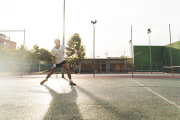 Wall Mural - Young Man Playing Tennis Outdoors.