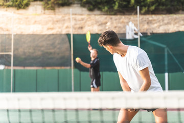 Wall Mural - Two Men Playing Tennis as a Team Outdoors.