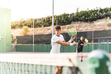 Wall Mural - Two Men Playing Tennis as a Team Outdoors.