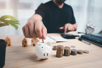 man hand putting coin on piggy bank.saving and financial planning concept.