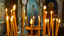 Blurred Wax Burning Candles In An Orthodox Church On The Icon Background.