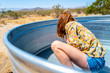 © Elijah Hurwitz - A woman in her twenties cleans a stock tank pool in the desert of Joshua Tree, California