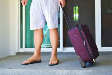  Man with travel suitcase at the door. To send on a journey.