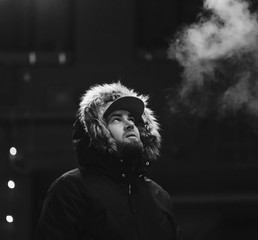 Wall Mural - bearded man smoking against the background of the night city