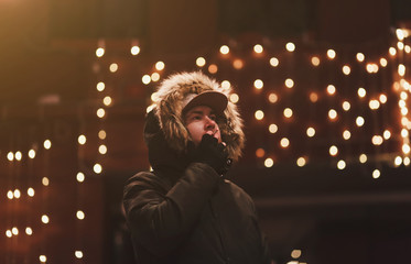 Wall Mural - Beautiful bearded young man smoking on the street in an urban setting