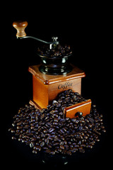 Wall Mural - Coffee beans and vintage wooden coffee grinder on black background.