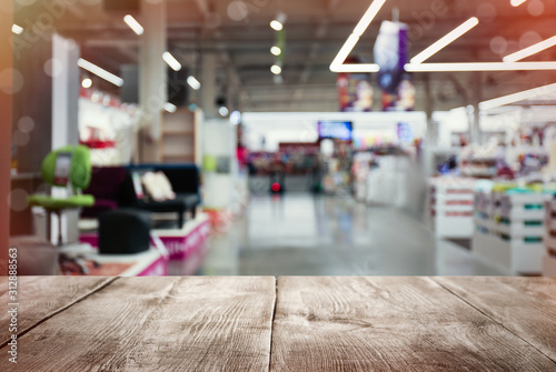 Fotomural Empty wooden surface and blurred view of furniture store in mall
