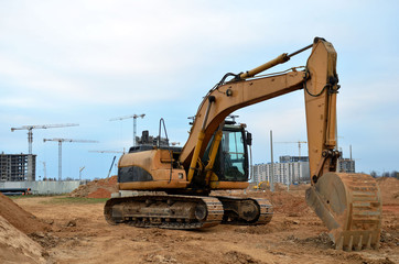 Excavator digs the ground for the foundation and construction of a new building. Road repair, asphalt replacement, renovating a section of a highway, laying or replacement of underground sewer pipes