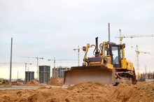 Bulldozer During Of Large Construction Jobs At Building Site. Land Clearing, Grading, Pool Excavation, Utility Trenching And Foundation Digging. Crawler Tractor,  Dozer, Earth-moving Equipment.