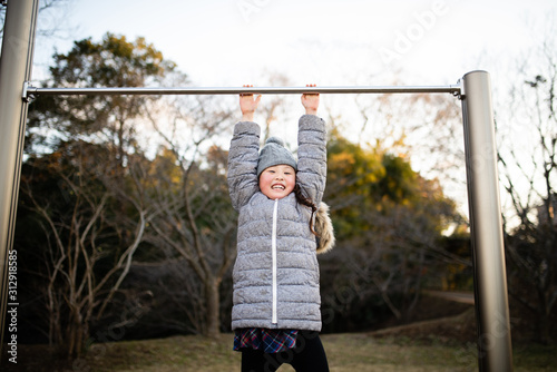 冬の公園で鉄棒で遊ぶ女の子 Stock Photo Adobe Stock