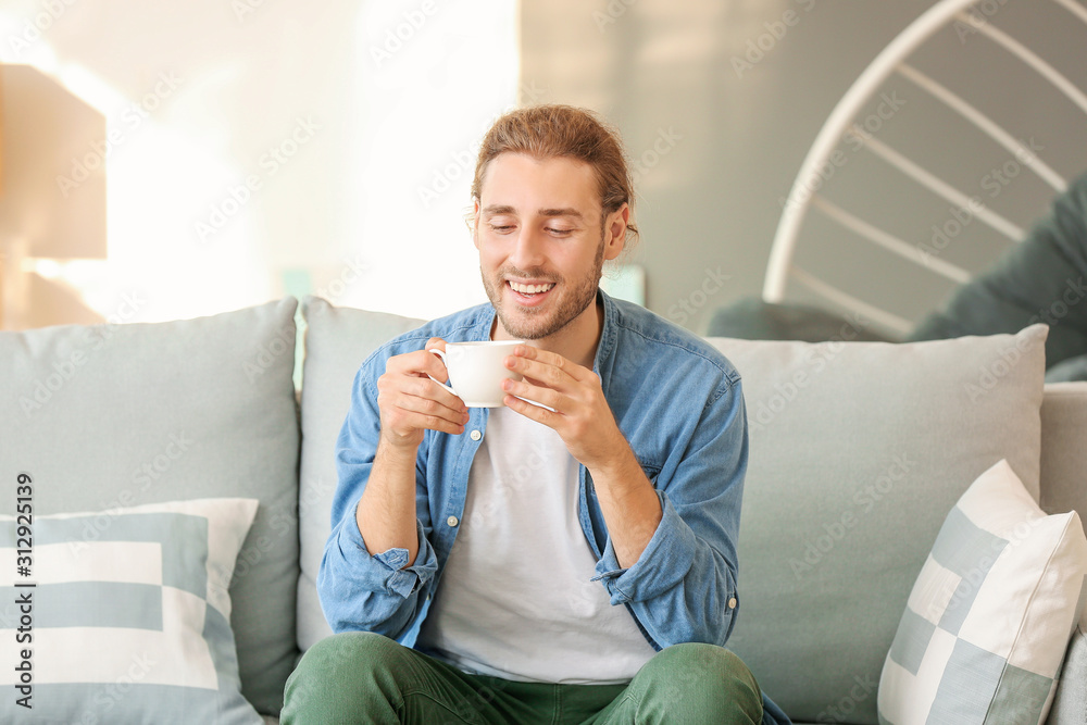 Handsome man drinking coffee at home