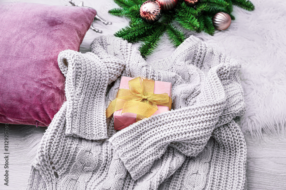 Beautiful Christmas composition with warm sweater, gift and decor