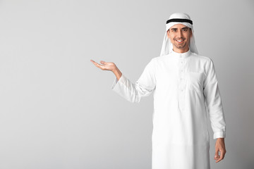 Wall Mural - Handsome Arab man on light background