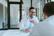 © bnenin - Smiling doctor talking with patient about insurance.