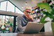 © bnenin - Portrait of a serious senior woman looking at laptop.