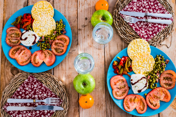 Above view of table with two dishes full of vegetables and diet healthy food on a wooden trendy table -coloured mix of tasty and seasonal fresh food ready for nutrition activity