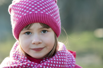 Wall Mural - Pretty child girl in warm knitted winter clothes outdoors.