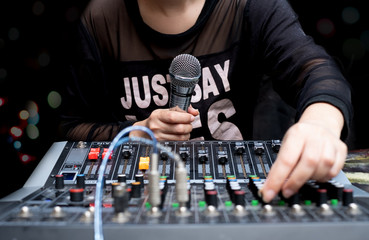 Woman hands holding microphone and mixing audio by sound mixer analog