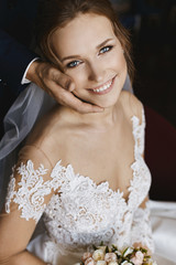 Wall Mural - Tender wedding portrait. Beautiful young bride leaning on groom's hand and keeping wedding bouquet. Bridal bouquet of pink and white rose flowers in the hands of model girl in trendy wedding dress.