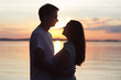 © Dziana - loving couple kissing at sunset. love in the sun. Valentine's day in nature beach