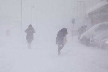 blizzard in longyearbyen . people in snowfall. abstract blurry winter weather background