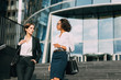 © Artem Varnitsin - Young businesswoman discussing with her colleague while walking down the stairs near an office building