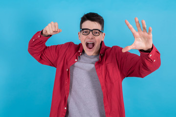 Wall Mural - young man or teenage student isolated on color background with hand and raised fist screaming