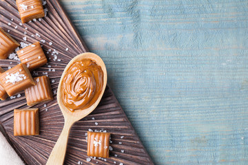 Poster - Salted caramel on blue wooden table, top view. Space for text