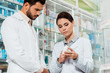 © LIGHTFIELD STUDIOS - Low angle view of pharmacist looking at jar with pills in pharmacy