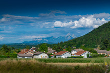 View Of A Mountain Town, Slopes Covered With Forest And Mountain Peaks In The Distance A Blue Sky With Clouds.Allinges Town.Haute-Savoie In France.