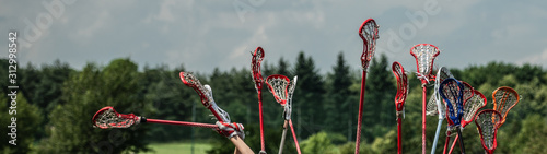 Fotografía lacrosse raised lacrosse sticks against the sky