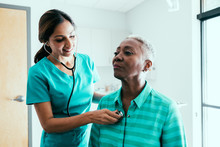 Nurse Listening To Stethoscope On Patient's Back