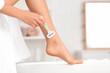 © Pixel-Shot - Beautiful young woman shaving legs in bathroom, closeup