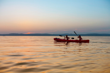 Canvas Print - Beautiful sunset over lake Balaton with kayaking girls