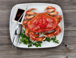 © tab62 - Whole Dungeness crab in dinner setting on wooden table in top view layout