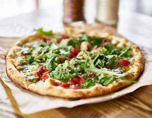 gourmet brick oven fired chicken and pesto pizza in restaurant