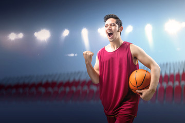 Poster - Asian man basketball player holding the ball with an excited expression