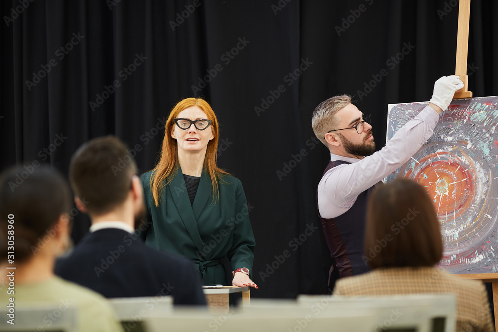 Woman and man preparing for the presentation they are going to present paintings to business people - obrazy, fototapety, plakaty 