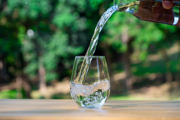 Wall Mural - Pouring pure water in to the glass make spread of water crystal bubble with background nature