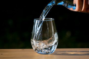 Wall Mural - Pouring pure water in to the glass make spread of water crystal bubble with background nature