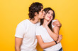 © F8  \ Suport Ukraine - Young lovely couple posing together making selfie and kissing over yellow background