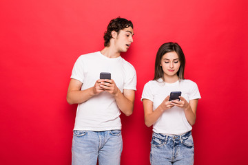 Sticker - Beautiful woman and handsome man typing with smart phones back to back each other over red background