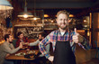 © Studio Romantic - Bearded waiter barista bartender standing against the background of the pub bar