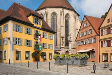 Dinkelsbühl, Bavaria, Germany - July 15, 2019; Colorful houses and the back of the church on a square in Dinkelsbühl an touristic town on the romantic road