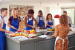 © Monkey Business - Male And Female Adult Students With Teacher Preparing Ingredients For Dish In Kitchen Cookery Class