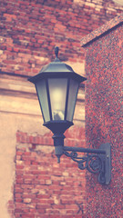 Wall Mural - An old street lamp on a brick wall, vintage toned