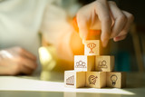Teamwork and Success concept.Hand holding wood block with icon Trophy cup,leader business.Key success factors for leadership elements.teamwork to goal success,copy space.