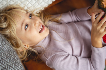 Cute little girl lying on couch at home